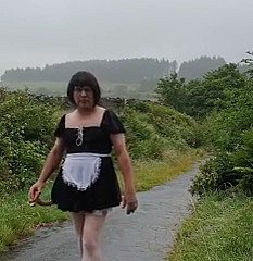 Transvestitenmädchen in the air einer öffentlichen Gasse im Regen